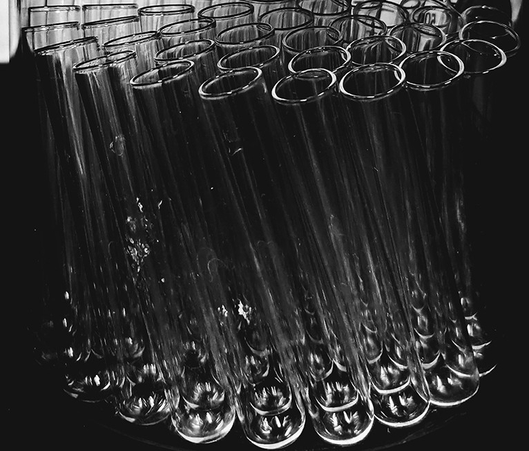 On the right, a black and white image of glass beakers.